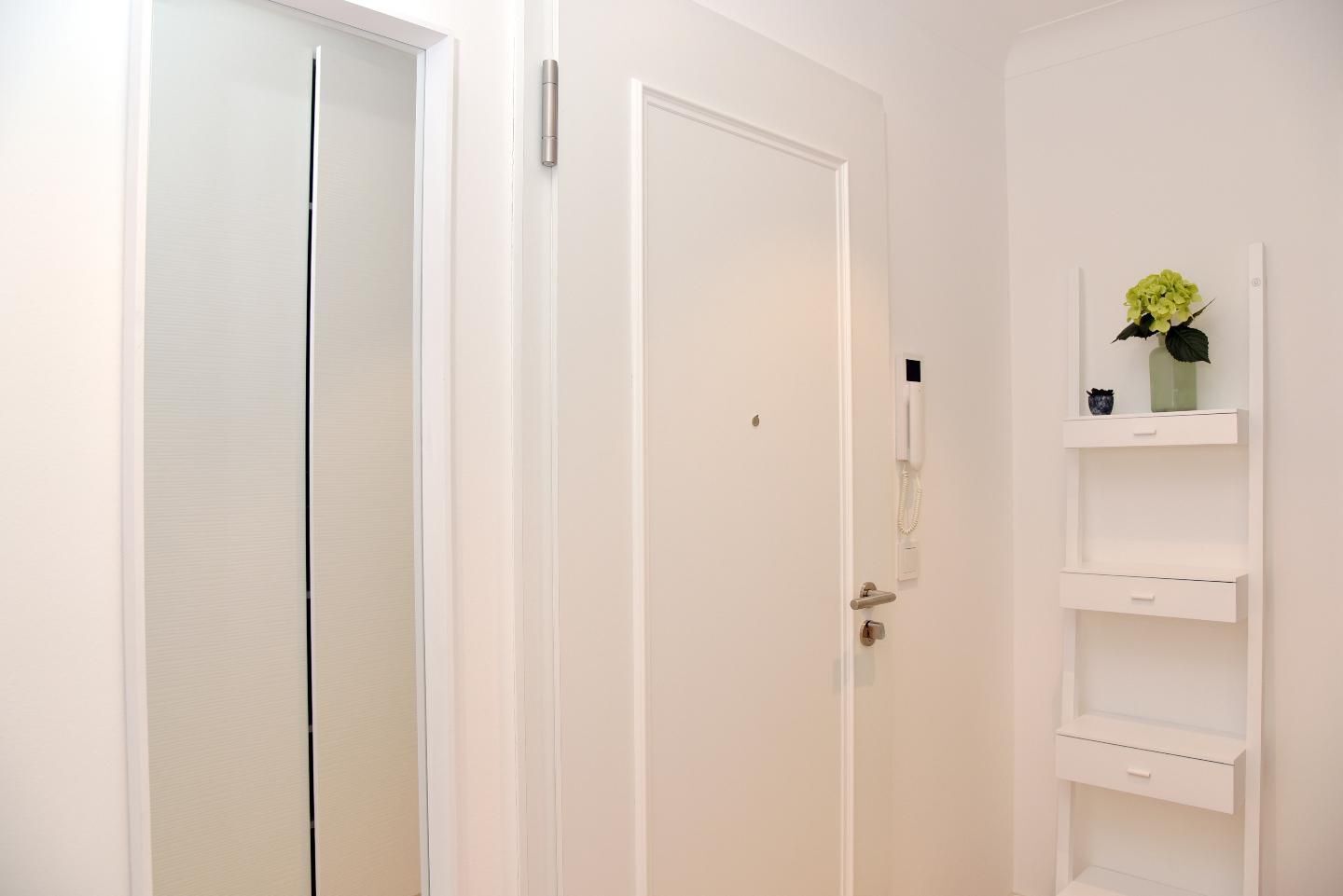 Una puerta blanca con cerradura y un pequeño candado.