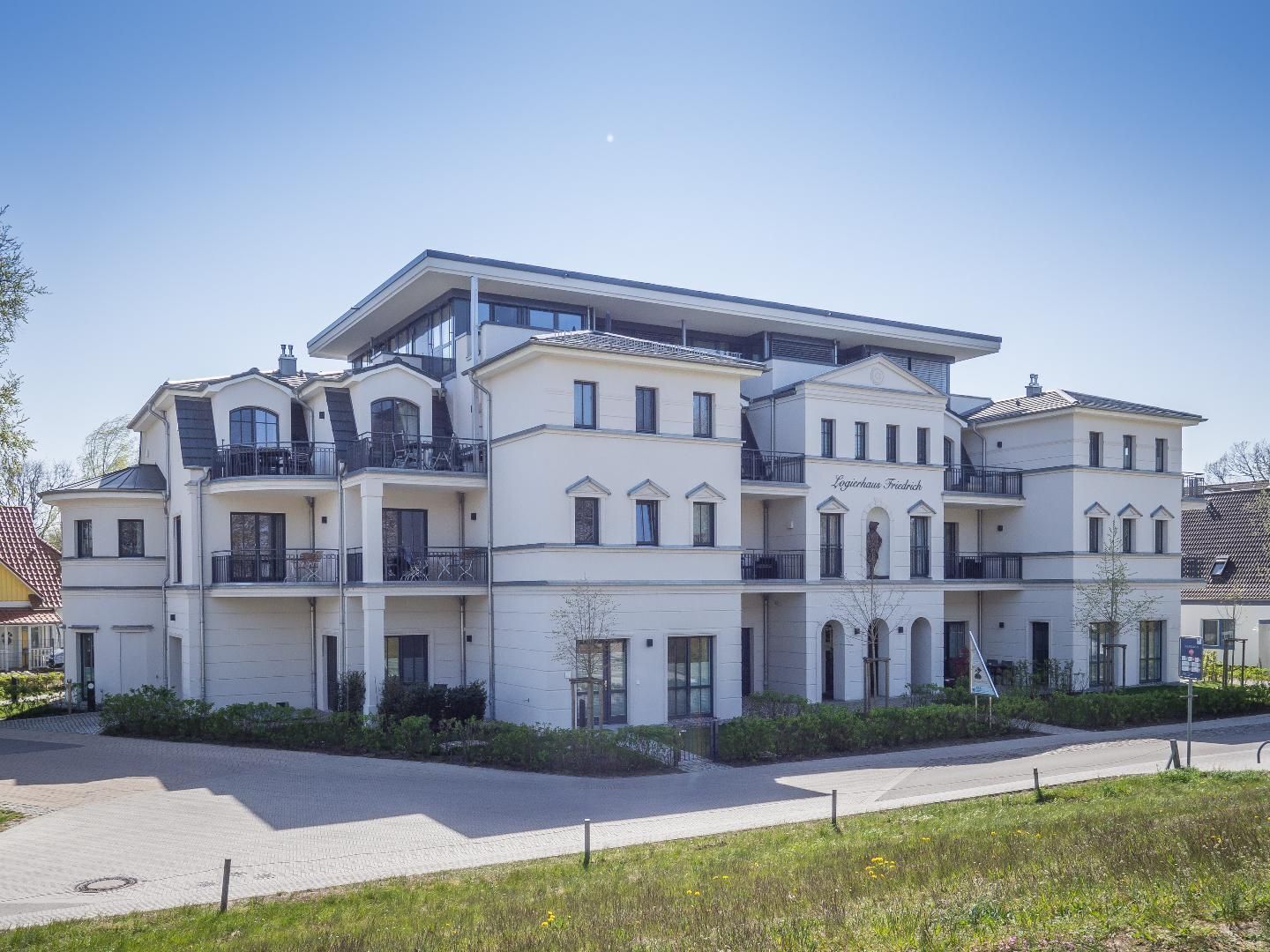 A multi-story hotel with a symmetrical facade, balconies, and a central entrance.