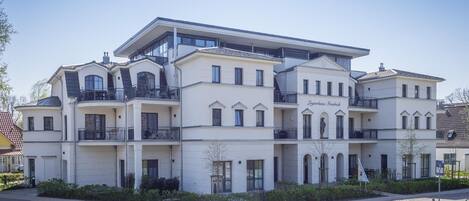 A multi-story hotel with a symmetrical facade, balconies, and a central entrance.