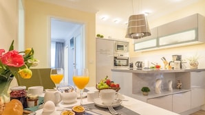 Een moderne keuken met een centraal eiland, voorzien van een magnetron, waterkoker en diverse keukengerei.