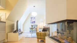 Een moderne woonkamer met een open haard, een eethoek en een keuken.