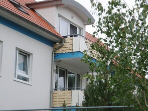Ein zweistöckiges Gebäude mit einem Balkon im oberen Stockwerk.