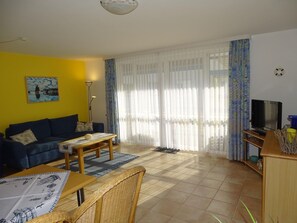 A living room with a sofa, coffee table, and television.