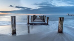 A wooden pier extending into calm waters with a cloudy sky. - Comfortable vacation apartment Residenz am Strand 1-11 in the first row to the Baltic Sea - (Zingst)