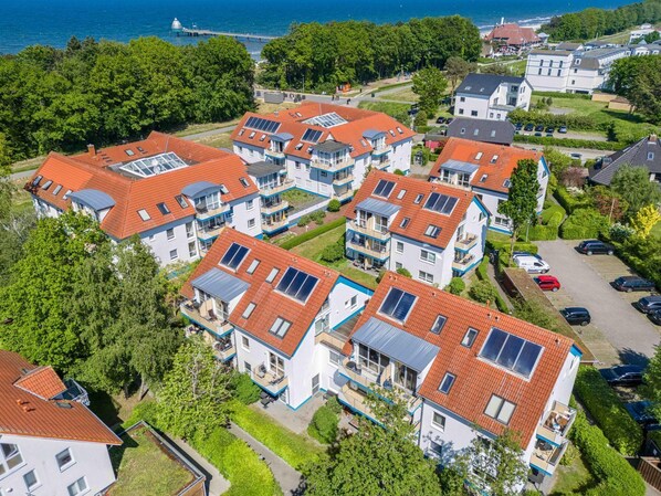 A residential area with multiple two-story houses featuring red-tiled roofs and solar panels.