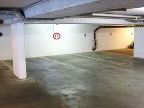An underground parking garage with concrete floors and white walls.