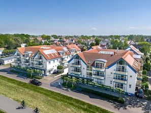 Ein Wohngebäude mit mehreren Balkonen, einem Innenhof und Blick auf die umliegende Nachbarschaft.