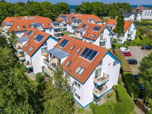Ein Wohngebiet mit modernen Häusern, die Satteldächer und Solaranlagen haben.