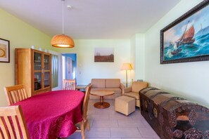 A cozy room with a dining table, chairs, a sofa, and a lamp. - Wuschels Hütt - Bright and friendly furnished vacation home with 2 bedrooms (Zingst)