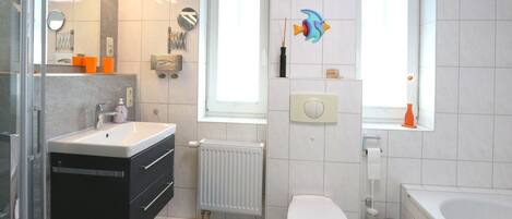 A modern bathroom with a toilet, sink, and bathtub.