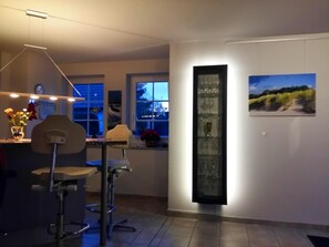 Eine moderne Küche mit Essbereich, einem hohen Glaskabinett und einem Fenster mit Blick.