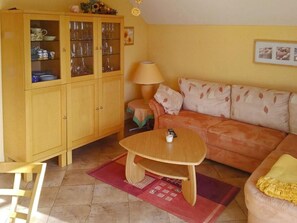 A living room with a wooden cabinet, a sofa, a coffee table, and a lamp.