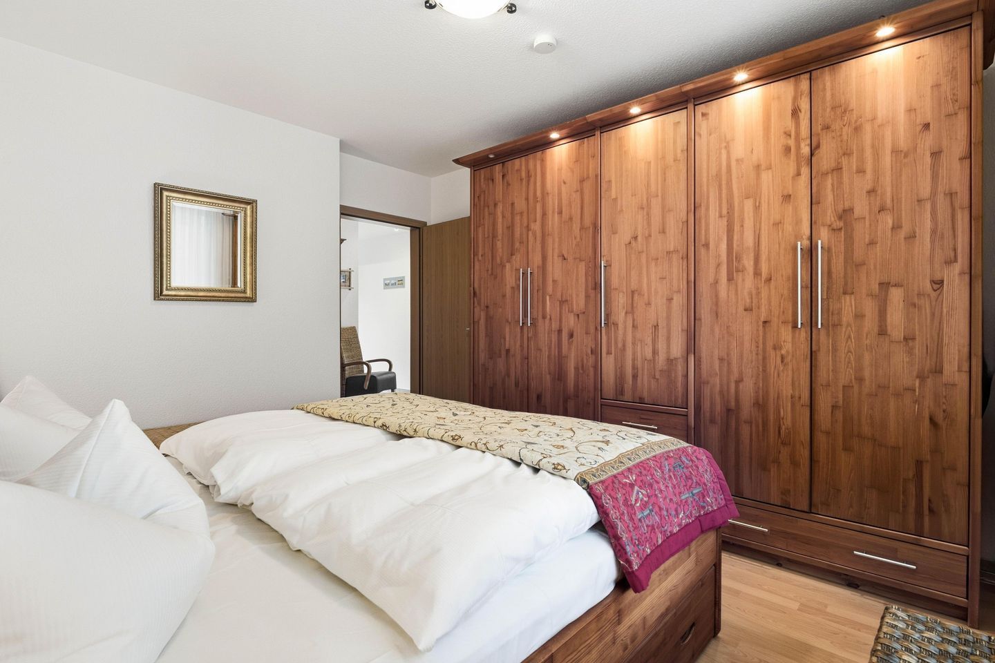 Ein Schlafzimmer mit einem Bett, einem Kleiderschrank und einem Spiegel.