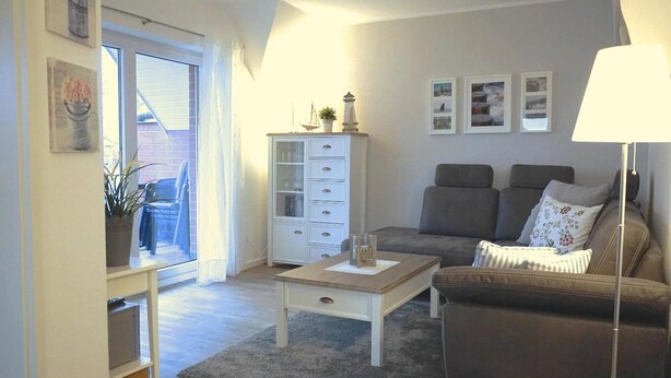 Ein Wohnzimmer mit einer Couch, einem Couchtisch, einem Schrank und einer Lampe.