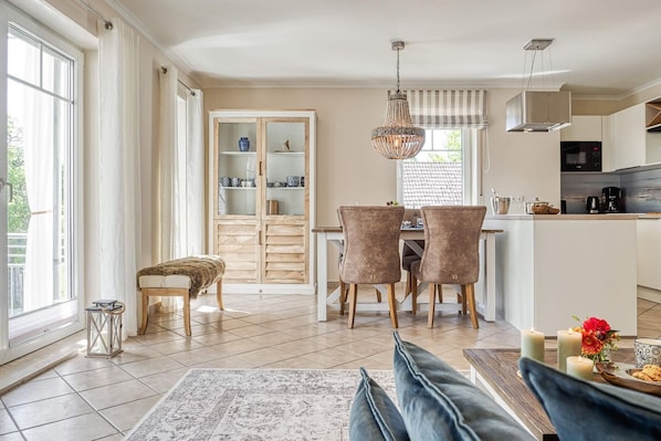 Una cocina moderna con comedor, un armario de madera con puertas de cristal y una banca.