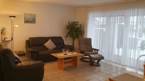 A living room with a sofa, armchair, and a coffee table.