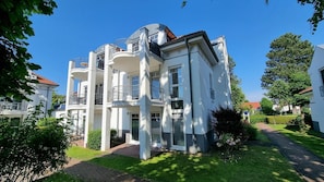 A multi-story residential building with balconies, a brick pathway, and surrounding greenery. - Comfortable vacation apartment Parkresidenz am Hafen HF 32 with terrace in Zingst - (Zingst)