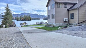 Une maison à deux étages avec un quai et des bateaux en arrière-plan.