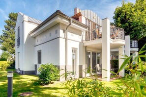 A modern two-story house with a balcony and a covered outdoor area. - Comfortable vacation apartment with balcony near the beach and center in Zingst - (Zingst)