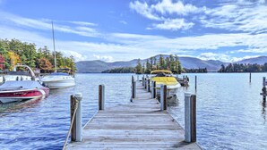 A wooden pier extending into calm waters with boats docked on both sides. - Bolton Landing Suite w/ Deck, Lake George Access (Bolton Landing)