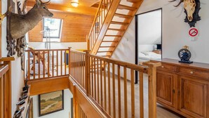 A wooden interior with a staircase, a deer head, and a skull on the wall. - Beautiful private villa for 14 guests with WIFI, private pool, TV, terrace and panoramic view (Jablonec Nad Nisou)