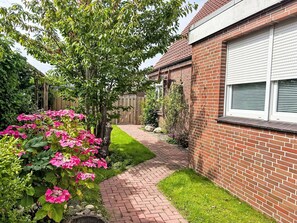 Stroll through the beautifully maintained garden, featuring a variety of plants and flowers, including vibrant blooms.