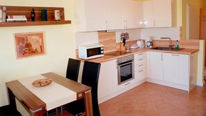 A compact kitchen with white cabinets, a microwave, a coffee maker, and a sink. - Comfortable apartment with balcony and modern furnishings in the Baltic Sea resort of Zingst (Zingst)