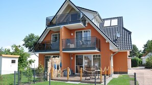 A two-story house with a balcony, a fenced yard, and a small shed. - Comfortable apartment with balcony and modern furnishings in the Baltic Sea resort of Zingst (Zingst)