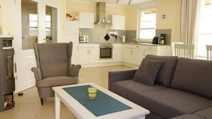 A modern kitchen with white cabinets, a built-in oven, and a coffee machine. - Comfortable vacation home with terrace, wood-burning stove and modern furnishings - (Prerow)