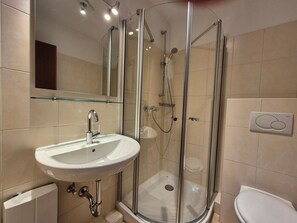 A modern bathroom with a glass-enclosed shower, a white sink, and a toilet. - Lindenhof - Gentle wave - "Gentle wave"... Beach chair on the beach included! (Dahme)