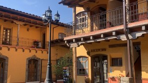 A traditional building with a balcony, stone wall, and a sign that reads "RECEPTION".