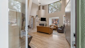 A modern living room with a fireplace, a television, and a large window.