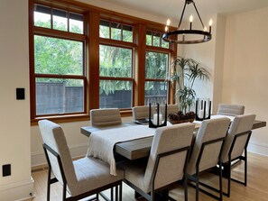 A dining area with a wooden table, six chairs, and a chandelier.