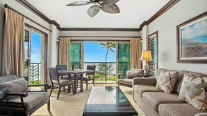 A hotel room with a balcony, a dining table, and a sofa. - A304 - Sprawling Ocean Views - Modern Luxury - Pool & AC on Kauai's East Side (Kapaa)