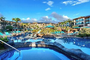 Ein Poolbereich mit Liegestühlen und einer Wasserrutsche.