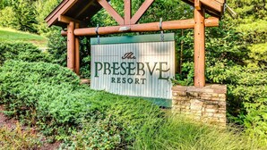 Une enseigne pour le complexe hôtelier The Preserve, avec une structure en bois et un socle en pierre.