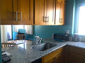 Enjoy cooking and making beverages in this kitchen with a sink, microwave, and coffee maker.