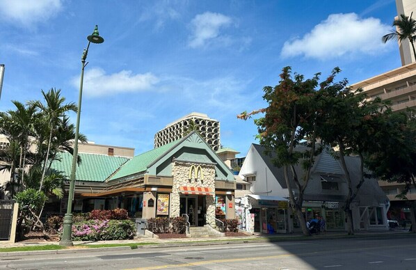 Un bâtiment doté d’un toit végétalisé et d’une façade en pierre, qui abrite un restaurant McDonald’s et un café.