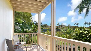 A wooden deck with a railing, a glass table, and two chairs. - 10 Bedroom Sleeps 24 w/ AC - Less than a 1 Minute Walk with views of Poipu Beach (Koloa)