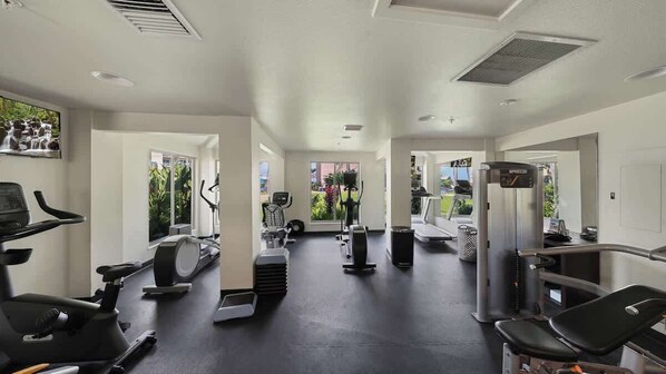 A gym with various exercise equipment, including treadmills, stationary bikes, and weight machines.