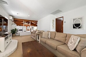 Relax in this stylish living room with a beige sofa, coffee table, and entertainment unit.