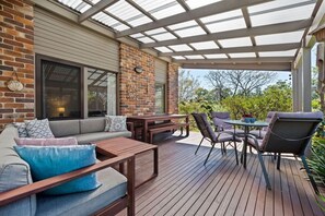 Relax in a serene outdoor space with a sofa, table, and chairs.