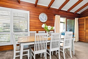 Enjoy meals in this cozy dining area with a wooden table and comfortable chairs.