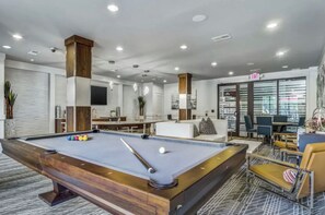 Relax in a stylish space with a pool table, comfortable seating, and a dining area.