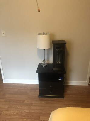 Cozy retreat with a nightstand, cabinet, and comfortable bed.