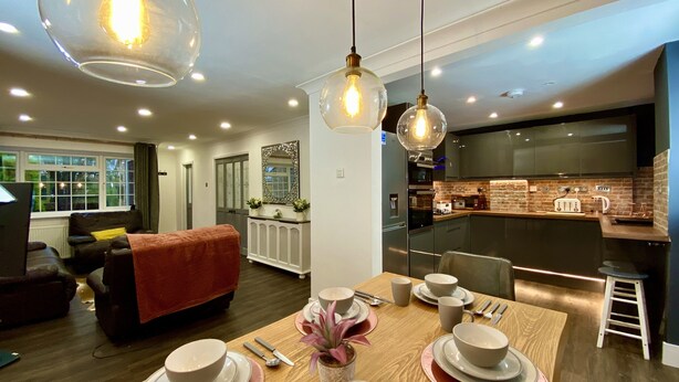 A modern kitchen with a brick backsplash, stainless steel appliances, and pendant lighting. - NEW Modern 4-Bed House, Deluxe Living, 3 Bathrooms (Reading)