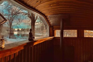 Een vakantiehuisje interieur met uitzicht op een besneeuwd landschap door een groot raam.