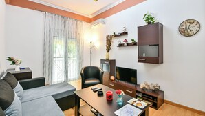 Ein modernes Wohnzimmer mit einer Couch, einem Esstisch, einem Fernseher und einem Bücherregal.