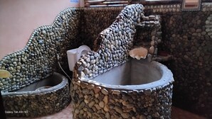 Toilet med vægge i stenteknik og et unikt design af håndvask.