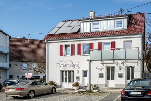 Un edificio con un letrero que dice 'Gästehaus Reck' y un letrero de estacionamiento.